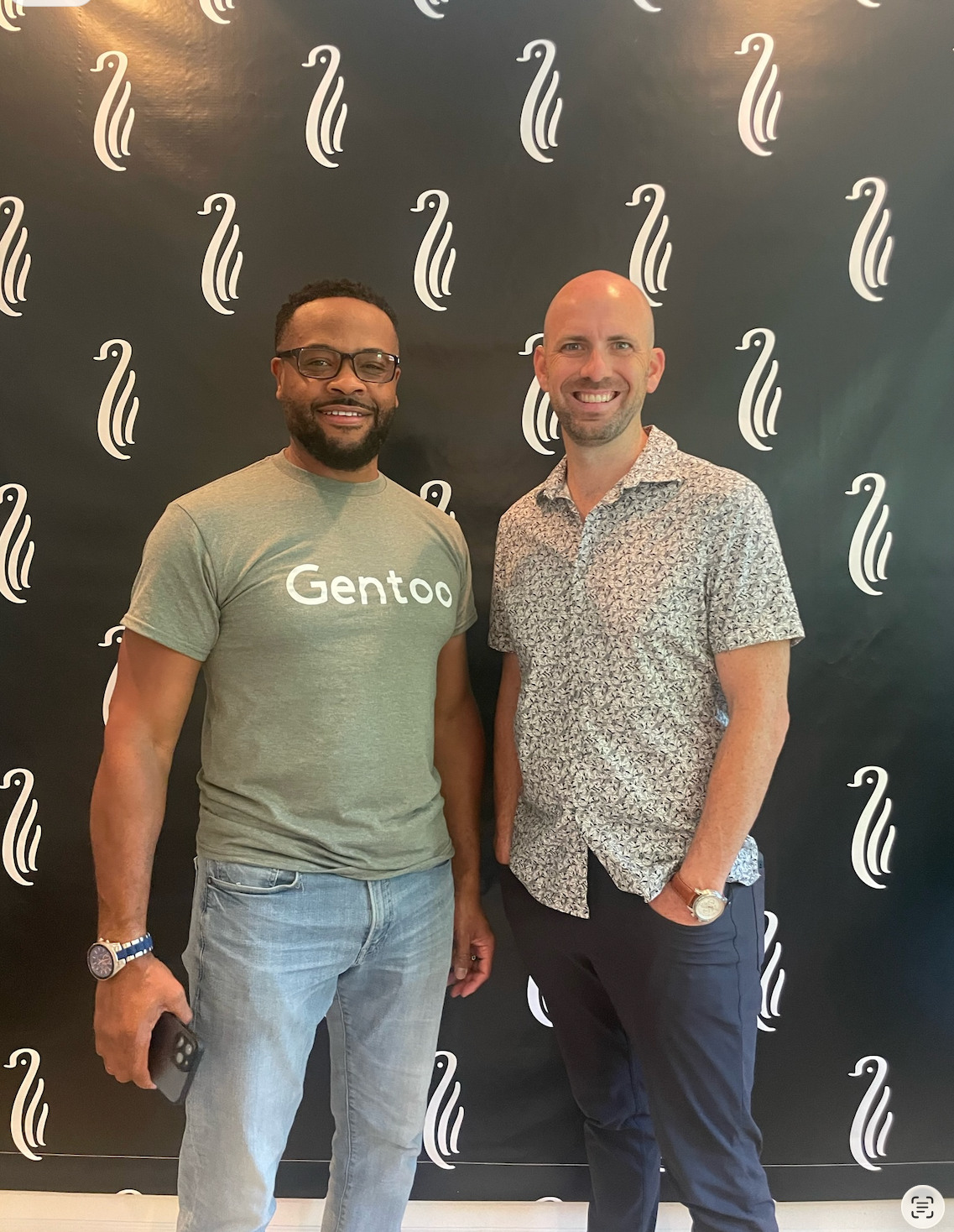 Two guests together in front of the Gentoo backdrop in 2023