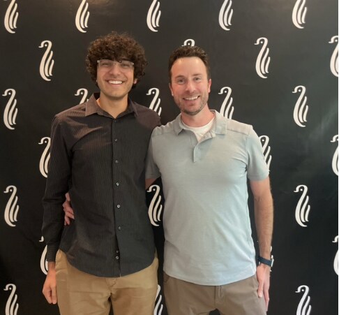 Two family members together in front of the Gentoo backdrop in 2023
